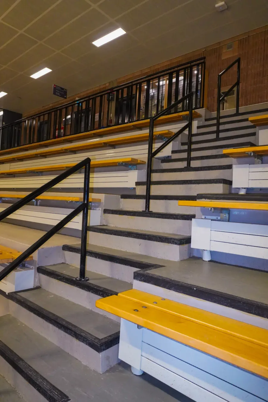 Rampe d’escalier en acier noir installée dans les gradins d’un aréna de la Ville de Montréal